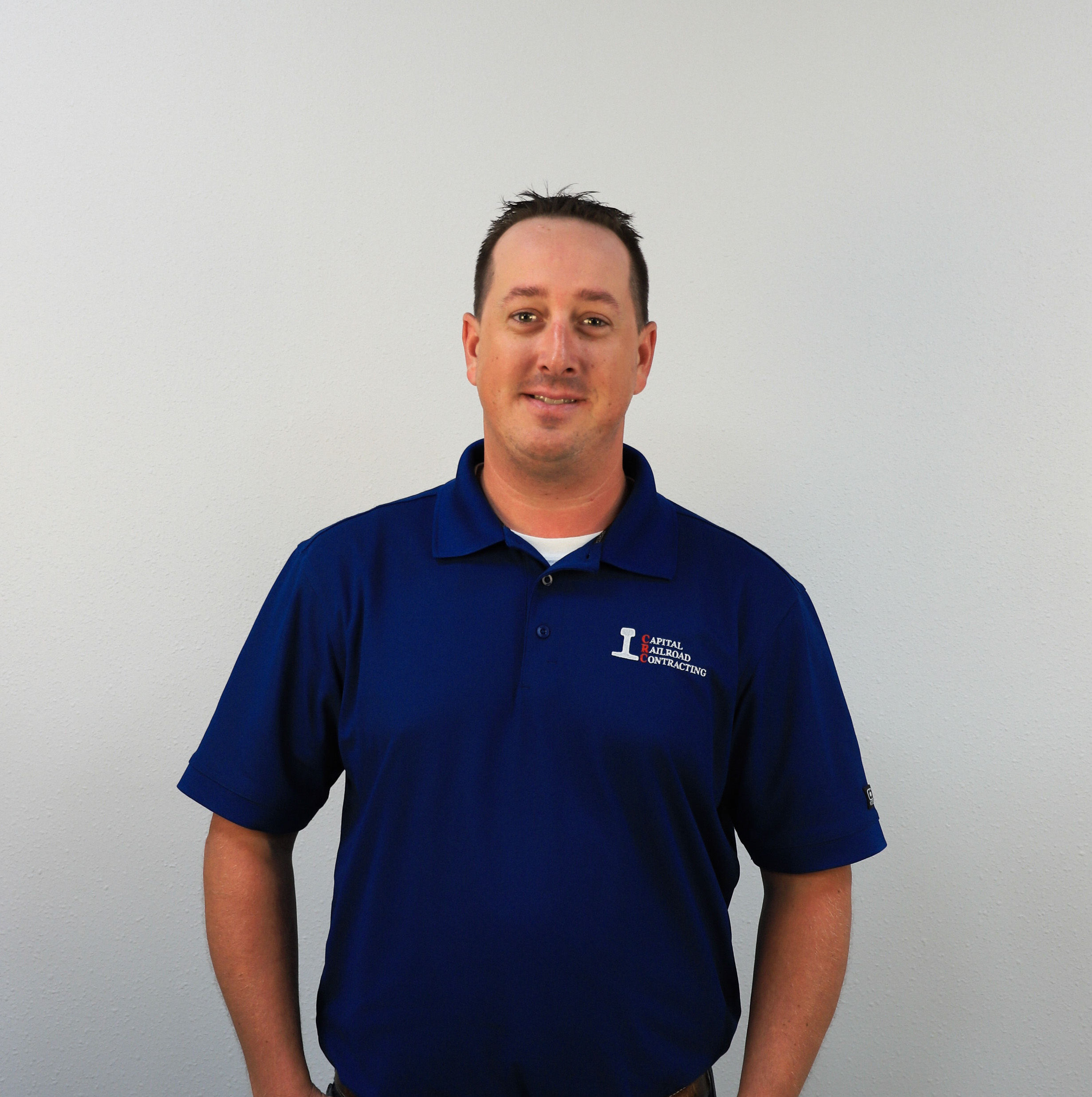 Man in blue polo shirt standing.