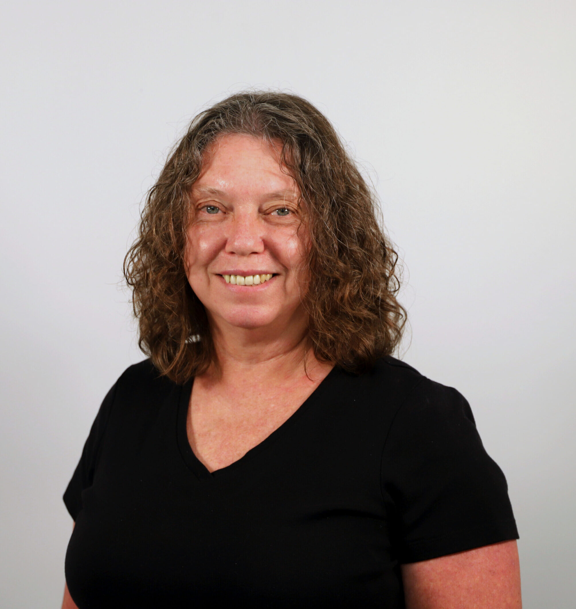 Woman with curly hair in black top.