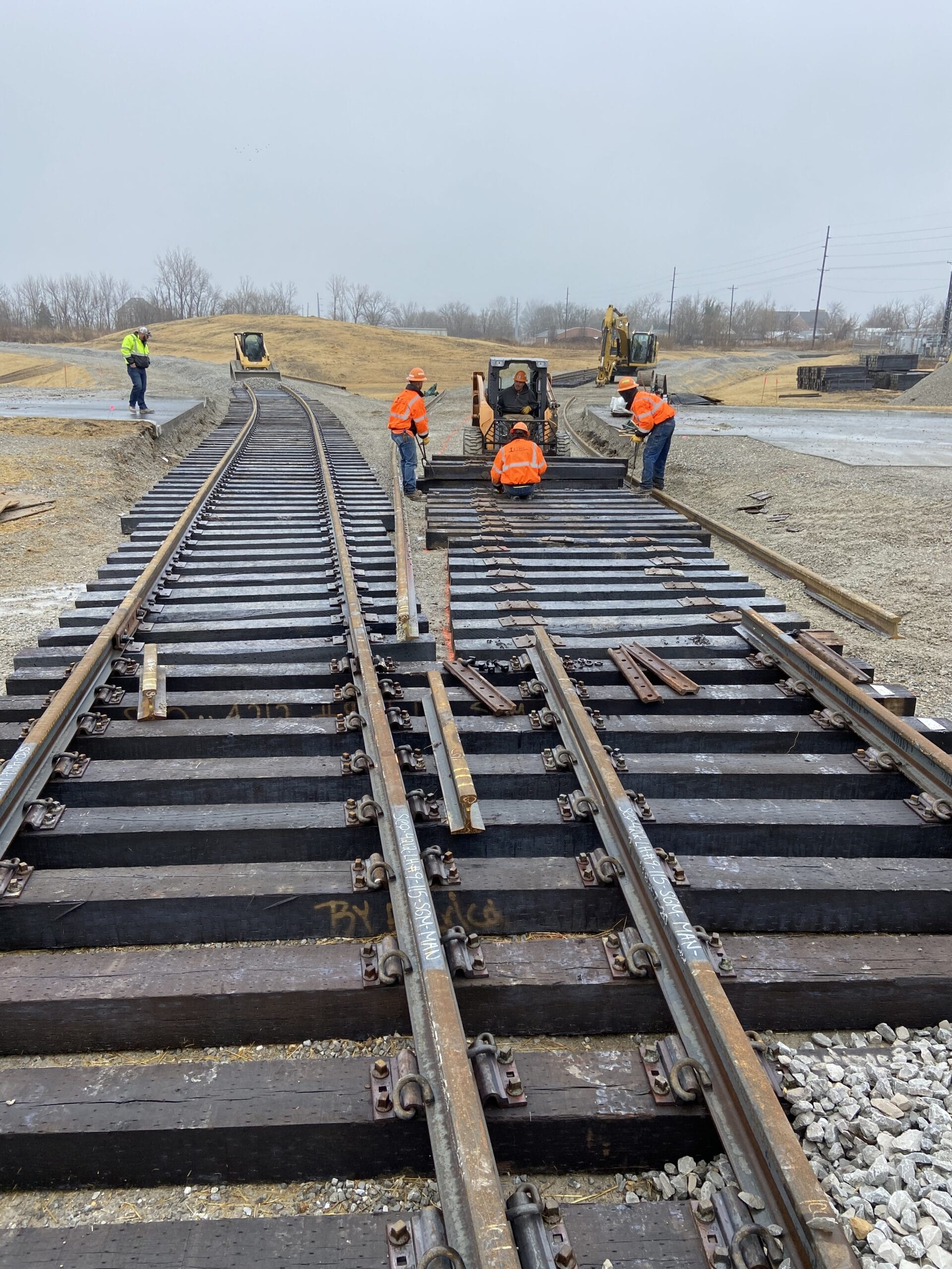 Workers repairing railway tracks together.