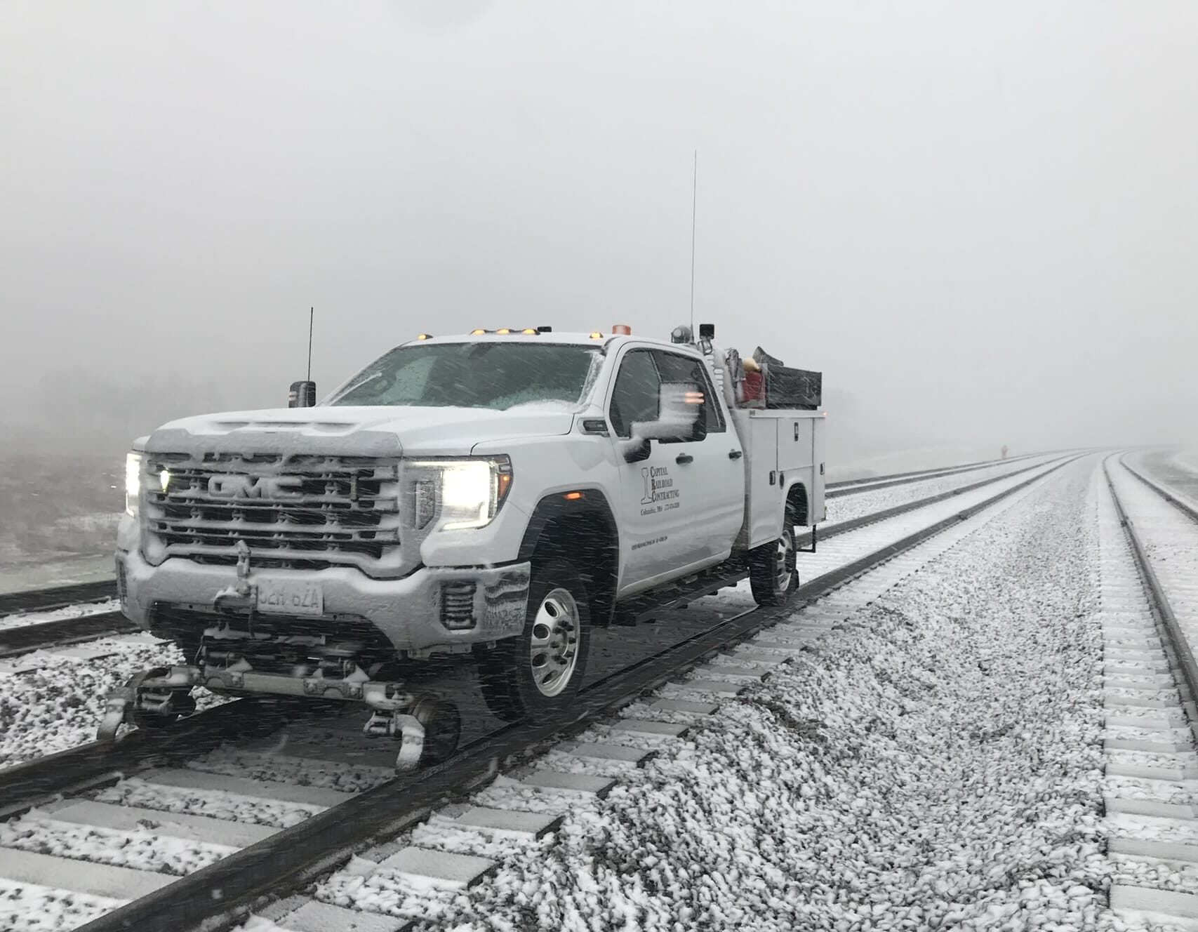 Truck on snowy railroad tracks