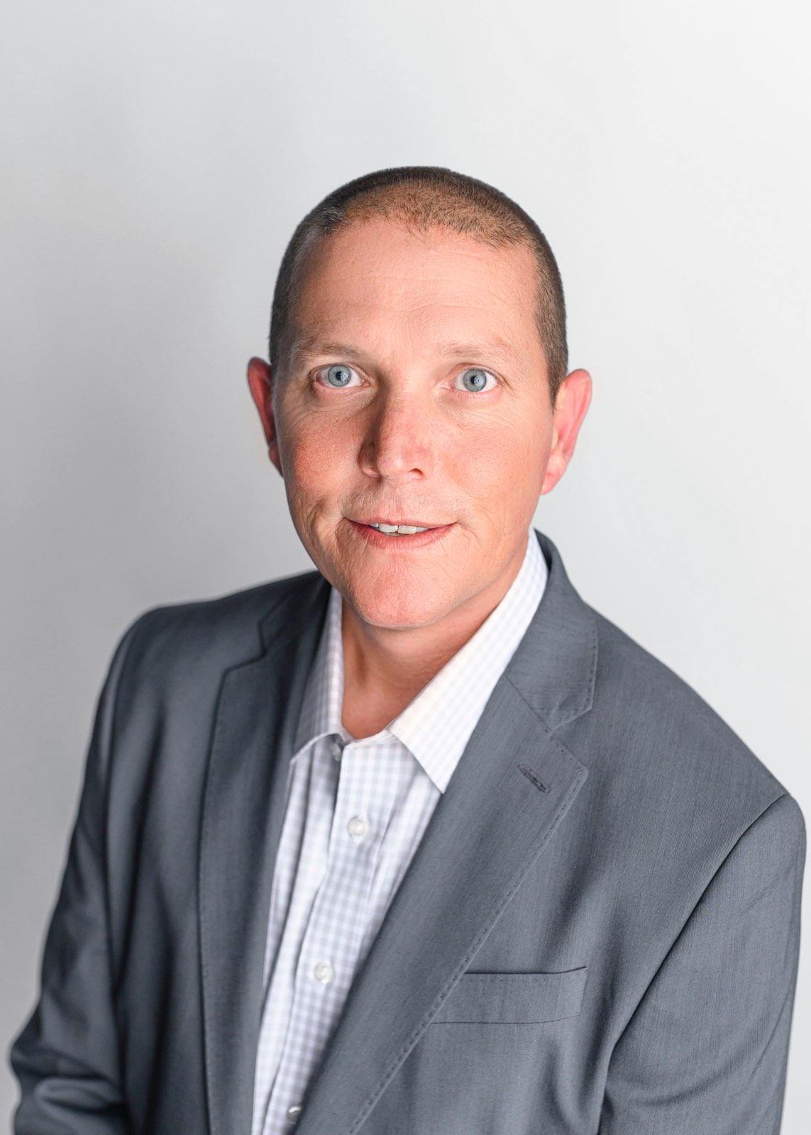 Man in gray suit, neutral background.