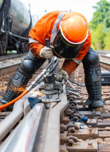 Worker welding on railway tracks
