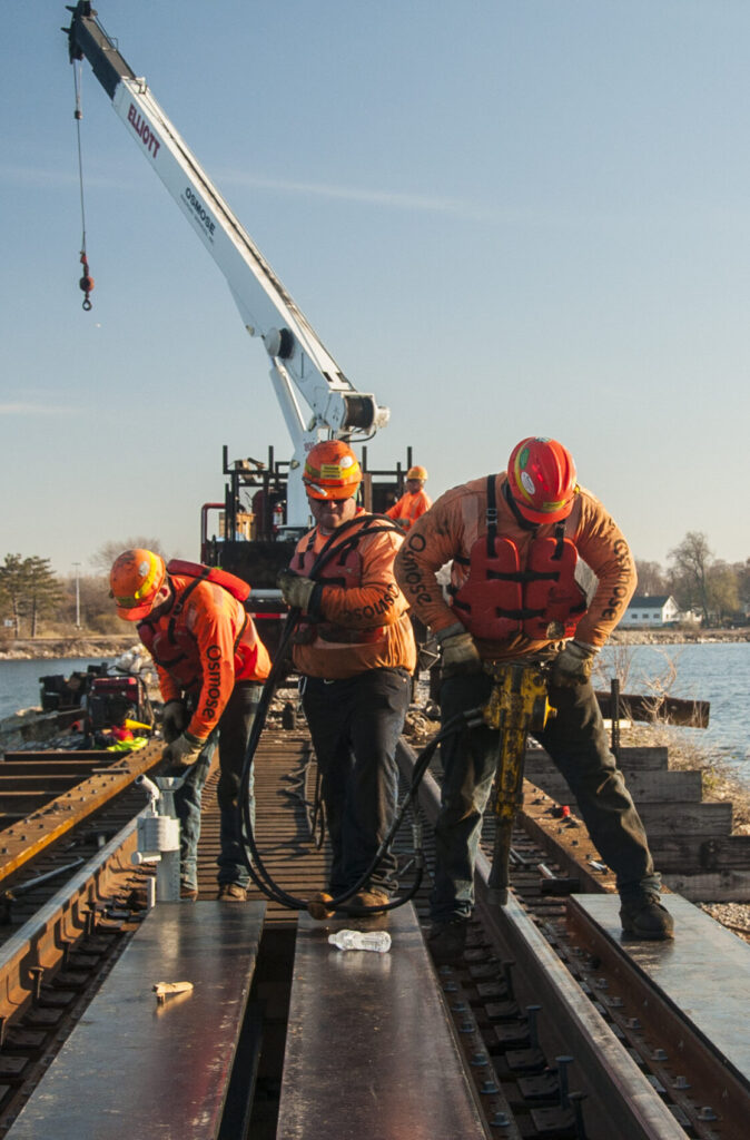 Workers on bridge with safety gear.